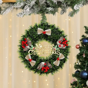 Detail of green pine Christmas wreath with pine cones, red berries and golden Merry Christmas sign