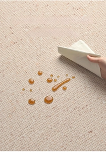 Macro view of water-resistant carpet fabric with droplets being wiped clean