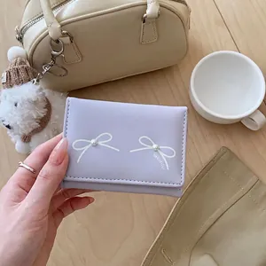 Lavender tri-fold short wallet for women featuring white bow and pearl embellishment