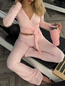 Ensemble de yoga rose avec haut à manches longues col en V et pantalon évasé taille haute