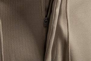 Detail of high-quality metal zipper and textured khaki fabric on men's trousers