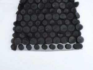 Dettaglio dell'abito in tulle nero con paillettes circolari 3D e tessuto in rete trasparente
