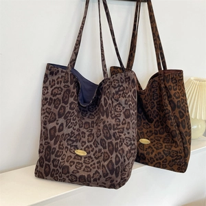 Detailed close-up of leopard print tote bags in grey and brown tones with fabric texture