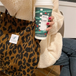 Detailed texture of leopard print corduroy tote bag with minimalist white woven label