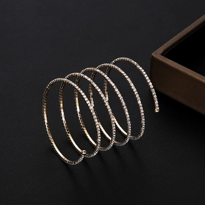 Detailed macro view of multi-layer spiral gold bracelet with shimmering crystals