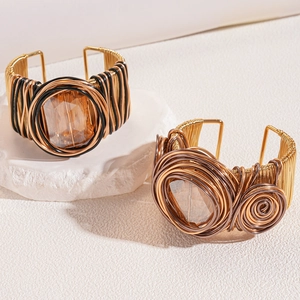 Detail of handmade wire-wrapped bangles with large amber gemstone on stone base