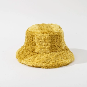 Close-up of thick mustard yellow plush bucket hat with soft faux fur texture for winter