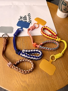 Close-up of multicolored braided phone wrist straps with adjustable buckles and link patches