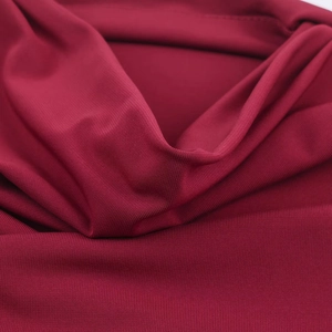 Close-up detail of burgundy knitted fabric showing texture and soft material sheen