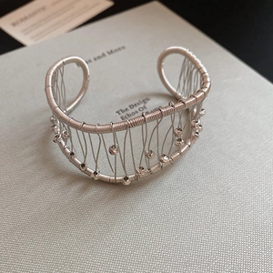 Detail view of silver woven wire cuff bracelet with decorative metallic beads decoration