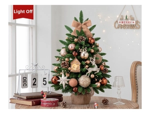 Close-up of mini Christmas tree with velvet bows, gold baubles, and lit wooden cabin