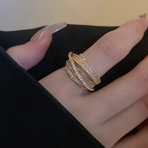 Macro view of gold-plated multi-layer crisscross ring with sparkling cubic zirconia pavé