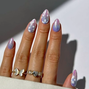 Uñas postizas cat-eye degradadas rosa y violeta con flores blancas y brillo de aurora