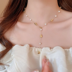 Dettaglio della collana a Y placcata oro 18k con perle irregolari e perline dorate