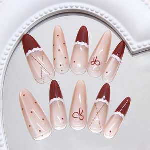 Handmade red French polka dot press-on nails with bow accents and cat-eye finish