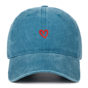 Dettaglio del ricamo a cuore rosso sul berretto da baseball in denim di cotone lavato