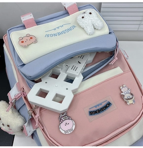Close-up of pink and blue nylon backpack featuring multi-compartments and cute pins
