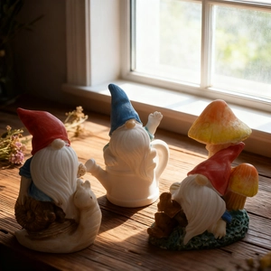 Three garden gnome figurines with snail, watering can, and mushroom on a sunny windowsill