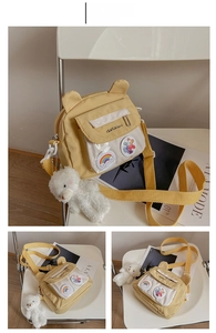 Detail view of yellow canvas crossbody bag with bear ears, clear pocket and plush charm