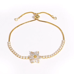 Détail du bracelet fleur en or ajustable avec oxydes de zirconium sur fond blanc neutre