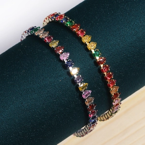 Macro detail of rainbow zircon bracelets with colorful pear-cut gems on velvet stand