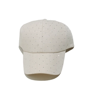 Détail d'une casquette beige avec strass scintillants sur tissu en coton sergé
