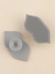 Detailed view of grey silicone lip brush showing massage bristles and suction cup back