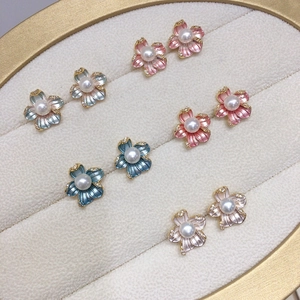 Detailed macro view of colorful enamel flower earrings with freshwater pearls and zircons
