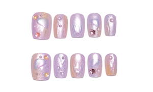 Detailed view of purple cat-eye press-on nails with pearls, rhinestones, and pink stars