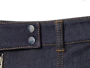 Vue détaillée de la taille d'un jean bleu foncé avec deux boutons métalliques et surpiqûres