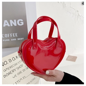 Close-up of a stylish red heart-shaped jelly handbag made of glossy patent leather material
