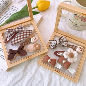 Detailed set of brown and beige fabric hair bows and clips in a transparent gift box