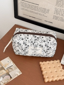 Dettaglio della borsa in velluto a coste crema con fiori e etichetta vintage