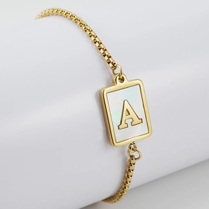 Detail view of a gold square shell pendant bracelet featuring a 3D letter A on a box chain