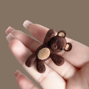 Vue détaillée de la pince à cheveux ours 3D en brun foncé avec texture velours
