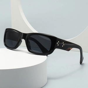 Square black sunglasses with gold star rivets on deep gray lenses with white pedestals