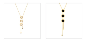 Detail of Y-shaped gold necklaces featuring white and black circular inlays with crystals