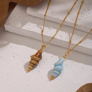 Waterproof stainless steel gold bead chain necklace with shell pendants on white stone