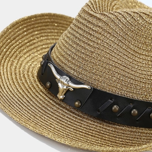 Western style straw hat featuring golden metallic fibers and a bull head leather buckle