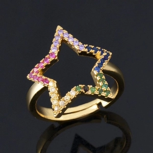 Minimalist gold star ring with colorful zircon pavé stones on a black reflective base