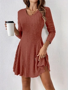 Detail of rust red knit dress featuring a V-neck cut and vertical ribbed texture fabric