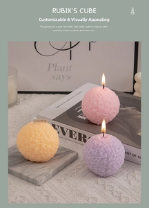 Three lit rose relief scented candles in pink orange and purple on marble tray
