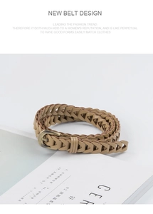 Close-up of light brown woven belt with antique bronze buckle on a book background