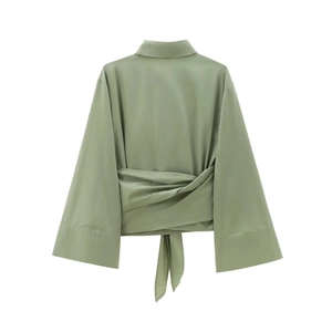 Détail d'une chemise en popeline vert herbe avec taille nouée et poignets larges