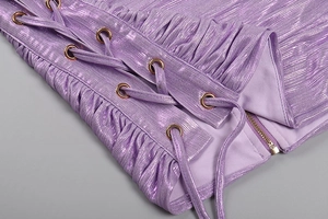 Detail of purple metallic dress featuring lace-up grommets and a gold metal side zipper