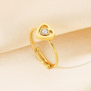 Makroaufnahme: Goldener Herzring mit weißem Zirkonia auf Seidenhintergrund
