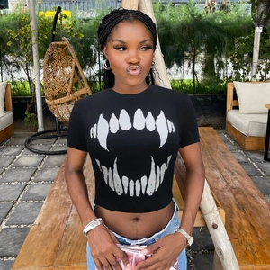 Détail d'un crop top noir à col rond avec impression graphique de dents de requin blanc