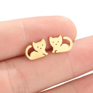 Cute gold hollow cat stud earrings held on finger showing minimalist animal style and size