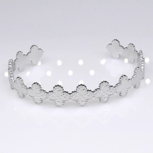 Detailed view of silver stainless steel cuff bracelet with quatrefoil hammered motifs