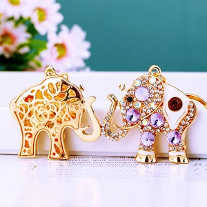 Close-up of golden elephant keychains with colorful crystals and hollow metal design